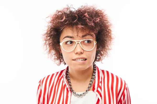 Komik kıvırcık kız suratını buruşturur ve dudaklarını ısırır.