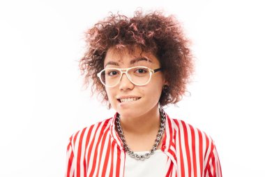 Komik kıvırcık kız suratını buruşturur ve dudaklarını ısırır.