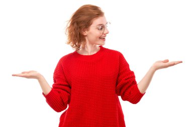 Kırmızı kazaklı çekici bir kız tanıtımcı elinde boş bir alan gösteren beyaz arka planda heyecanlı bir yüz var.