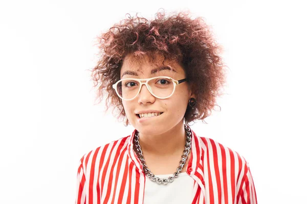 Komik kıvırcık kız suratını buruşturur ve dudaklarını ısırır.