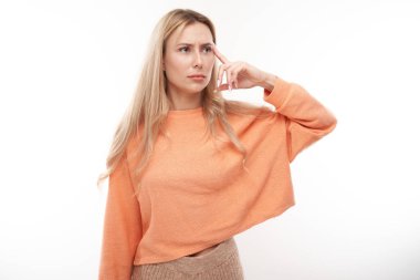 Kafasını rahat tutan zeki sarışın kız şüphelerini düşünüyor, kararlarını beyaz stüdyo geçmişinde izole ediyor.