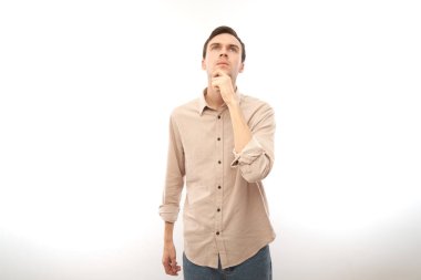 Sıradan dokunuşlar yapan zeki esmer adam çenesinden şüphe duyuyor, kararlarını mavi stüdyonun arka planında yalnız bırakıyor.