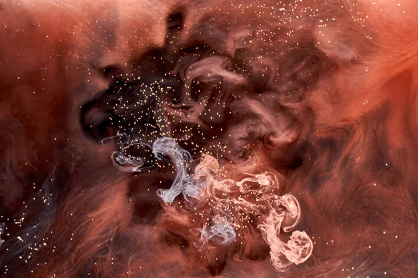 Siyah mürekkep arka planında turuncu duman, renkli sis, soyut girdap dokunuşu okyanus denizi, akrilik boya pigmenti su altında