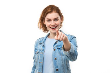 Dost canlısı kızıl saçlı kızın portresi seni seçiyor, beyaz arka planda izole edilmiş kamerayı işaret ediyor.