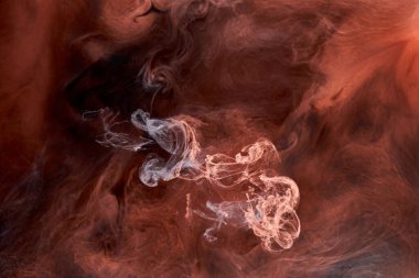 Siyah mürekkep arka planında turuncu duman, renkli sis, soyut girdap dokunuşu okyanus denizi, akrilik boya pigmenti su altında