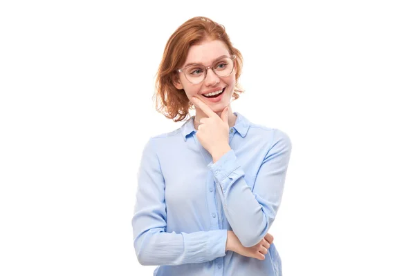 戴眼镜 身穿商务衫 聪明红头发的女孩满腹狐疑 在白色的工作室背景下做出了孤立的决定 — 图库照片