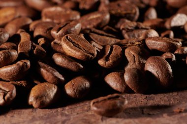 Kavrulmuş kahve çekirdekleri, kahverengi grunge arka planda izole edilmiş.