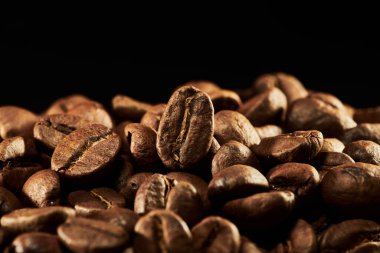 Kavrulmuş kahve çekirdekleri izole edilmiş. Siyah arka plana yakın, kırpma yolu.