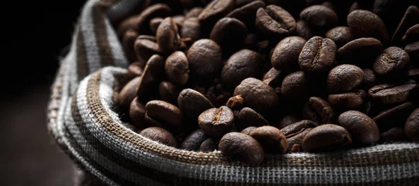 Roasted coffee beans in a bag closeup background