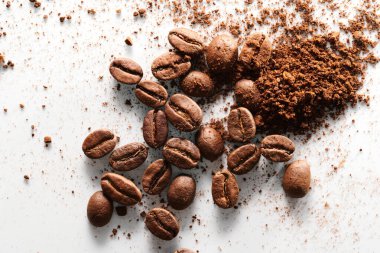Kavrulmuş kahve çekirdekleri farklı türde öğütülmüş ve tamamen izole edilmiş. Beyaz arka planda.
