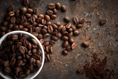 Kavrulmuş kahve çekirdekleri izole edilmiş, kahverengi grunge arka planda.