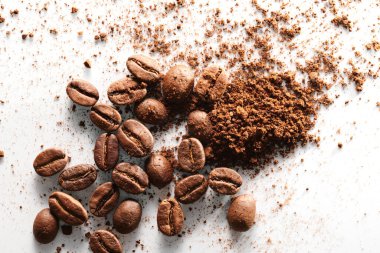 Kavrulmuş kahve çekirdekleri farklı türde öğütülmüş ve tamamen izole edilmiş. Beyaz arka planda.