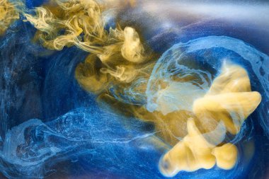 Sıvı akışkan sanat özgeçmişi. Mavi sarı dans eden akrilik boyalar suyun altında, okyanus dumanı