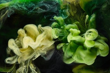 Sıvı akışkan sanat özgeçmişi. Yeşil dans eden akrilik boyalar su altında, kozmik duman okyanusu