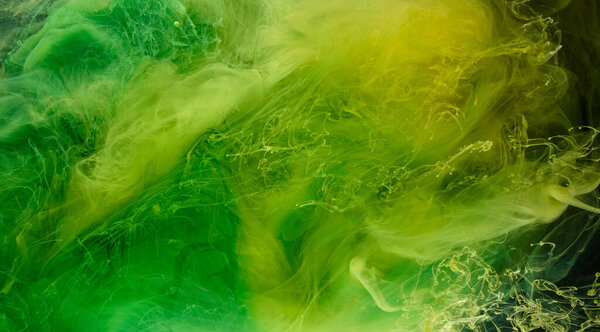 Liquid fluid art abstract background. Green, yellow dancing acrylic paints underwater, space smoke ocean, color explosion