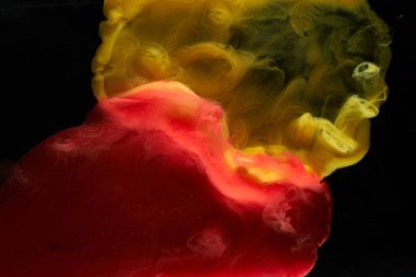 Sıvı akışkan sanat özgeçmişi. Kırmızı, sarı dans eden akrilik boyalar su altında, uzay dumanı okyanusu, renk patlaması