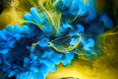 Sıvı akışkan sanat özgeçmişi. Mavi sarı dans eden akrilik boyalar suyun altında, okyanus dumanı