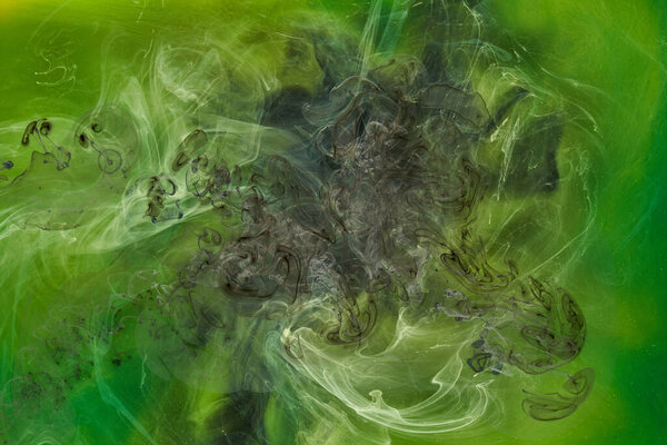 Liquid fluid art abstract background. Green dancing acrylic paints underwater, cosmic smoke ocean