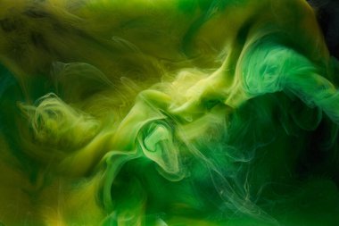 Sıvı akışkan sanat özgeçmişi. Yeşil, sarı dans eden akrilik boyalar suyun altında, uzay dumanı okyanusu, renk patlaması