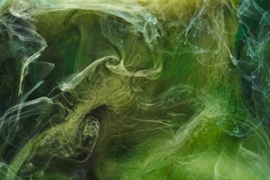 Sıvı akışkan sanat özgeçmişi. Yeşil dans eden akrilik boyalar su altında, kozmik duman okyanusu