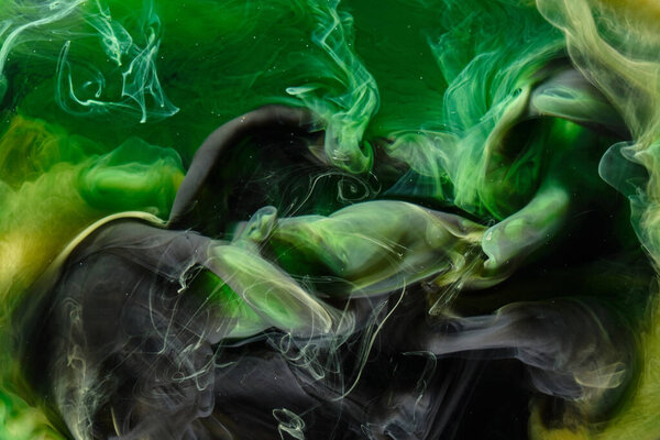Liquid fluid art abstract background. Green dancing acrylic paints underwater, cosmic smoke ocean