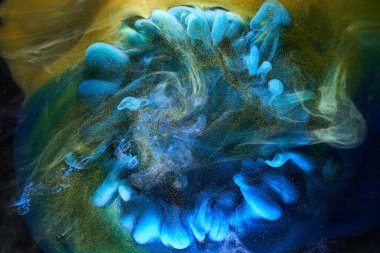 Sıvı akışkan sanat özgeçmişi. Mavi sarı dans eden akrilik boyalar suyun altında, okyanus dumanı