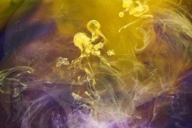Sıvı akışkan sanat özgeçmişi. Mor, sarı dans eden akrilik boyalar suyun altında, uzay dumanı okyanusu, renk patlaması