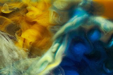 Sıvı akışkan sanat özgeçmişi. Mavi sarı dans eden akrilik boyalar suyun altında, okyanus dumanı