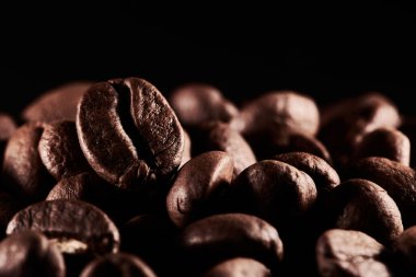 Kavrulmuş kahve çekirdekleri izole edilmiş. Siyah arka plana yakın, kırpma yolu.
