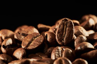 Kavrulmuş kahve çekirdekleri izole edilmiş. Siyah arka plana yakın, kırpma yolu.
