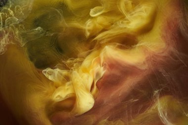 Sıvı akışkan sanat özgeçmişi. Dans eden akrilik boyaların sarı karışımı su altında, uzay dumanı okyanusu, renk patlaması