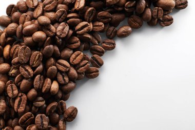 Kavrulmuş kahve çekirdekleri beyaz arka planda izole edilmiş, kırpma yolu.