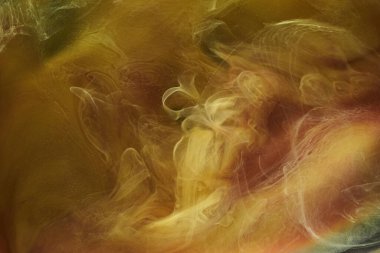 Sıvı akışkan sanat özgeçmişi. Dans eden akrilik boyaların sarı karışımı su altında, uzay dumanı okyanusu, renk patlaması