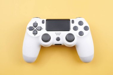 Beyaz video oyun denetleyici, oyun konsolu için joystick sarı arka planda izole. Oyuncu kontrol aygıtı yakın plan