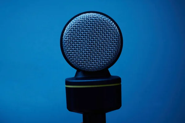 Fekete Mikrofon Elszigetelt Kék Háttér Közelről — Stock Fotó