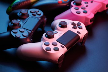 Oyun konsolu için çok farklı oyun kontrolörleri, çok renkli joystickler siyah arkaplanda izole edilmiş. Oyuncu kontrol cihazları yakın plan