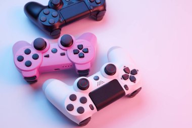 Oyun konsolu için beyaz arka planda izole edilmiş üç oyun kumandası, joystick. Oyuncu kontrol cihazları yakın plan