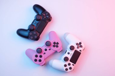 Oyun konsolu için beyaz arka planda izole edilmiş üç oyun kumandası, joystick. Oyuncu kontrol cihazları yakın plan