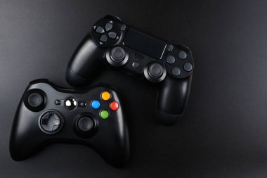 Oyun konsolu için siyah arka planda izole edilmiş iki oyun kumandası, joystick. Oyuncu kontrol cihazları yakın plan