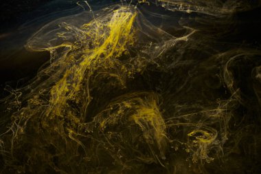 Sıvı akışkan sanat özgeçmişi. Siyah, sarı dans eden akrilik boyalar suyun altında, uzay dumanı okyanusu