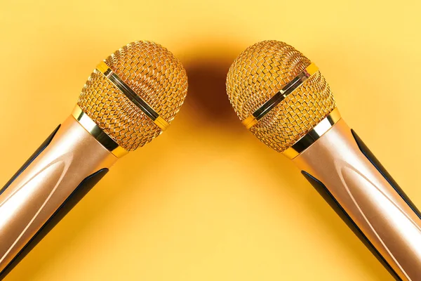 Dois Microfones Dourados Isolados Fundo Amarelo Perto — Fotografia de Stock