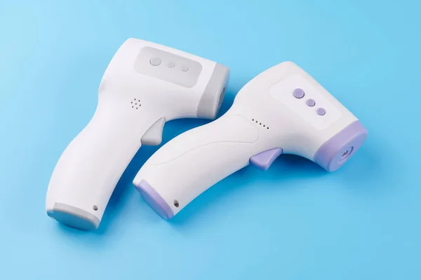 Temperature Measurement electronic Device. Isometric Digital Infrared Non-Contact Thermometer Gun isolated on blue background. medical diagnostic and healthcare concept