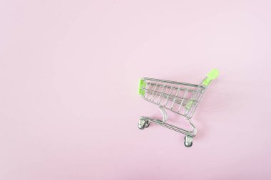 Pembe arka planda bir alışveriş arabası, kopyalama alanı; E-ticaret