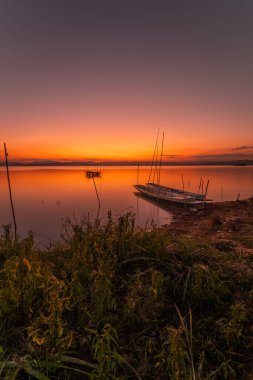 Two small boats moored on the shore of the lake. at sunset beautiful light