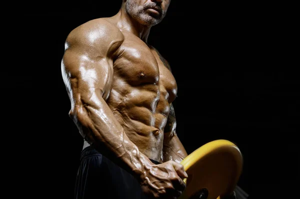 筋肉と筋肉の強いボディビルダーは ジムでのワークアウトで筋肉を汲み上げる運動能力のある男です スポーツとヘルスケアの概念の背景 — ストック写真