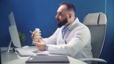 Doktorların ofisinde online danışma. Doktor, omurga, fıtık ve yaralanma bölümlerini göstermiş. Uzaktan kumandalı hasta danışmanı. İlaç ve sağlık hizmetleri kavramı