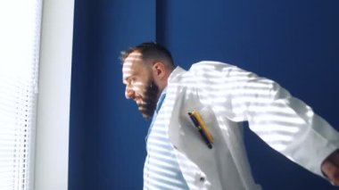 Doktor medikal bir sabahlık giyer ve muayenehaneye gider. Sağlık hizmeti kavramı