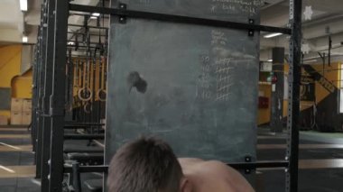 Spor salonunda göğüs presi yapan kaslı atletik bir adam. Omuz kasları çalışıyor. Spor, ağırlık kaldırma ve sağlık hizmetleri kavramı