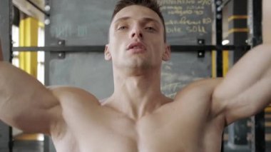 Spor salonunda göğüs presi yapan kaslı atletik bir adam. Omuz kasları çalışıyor. Spor, ağırlık kaldırma ve sağlık hizmetleri kavramı