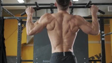 Spor salonundaki kaslı atletik adam barfiks çekiyor. Spor, ağırlık kaldırma ve sağlık hizmetleri kavramı